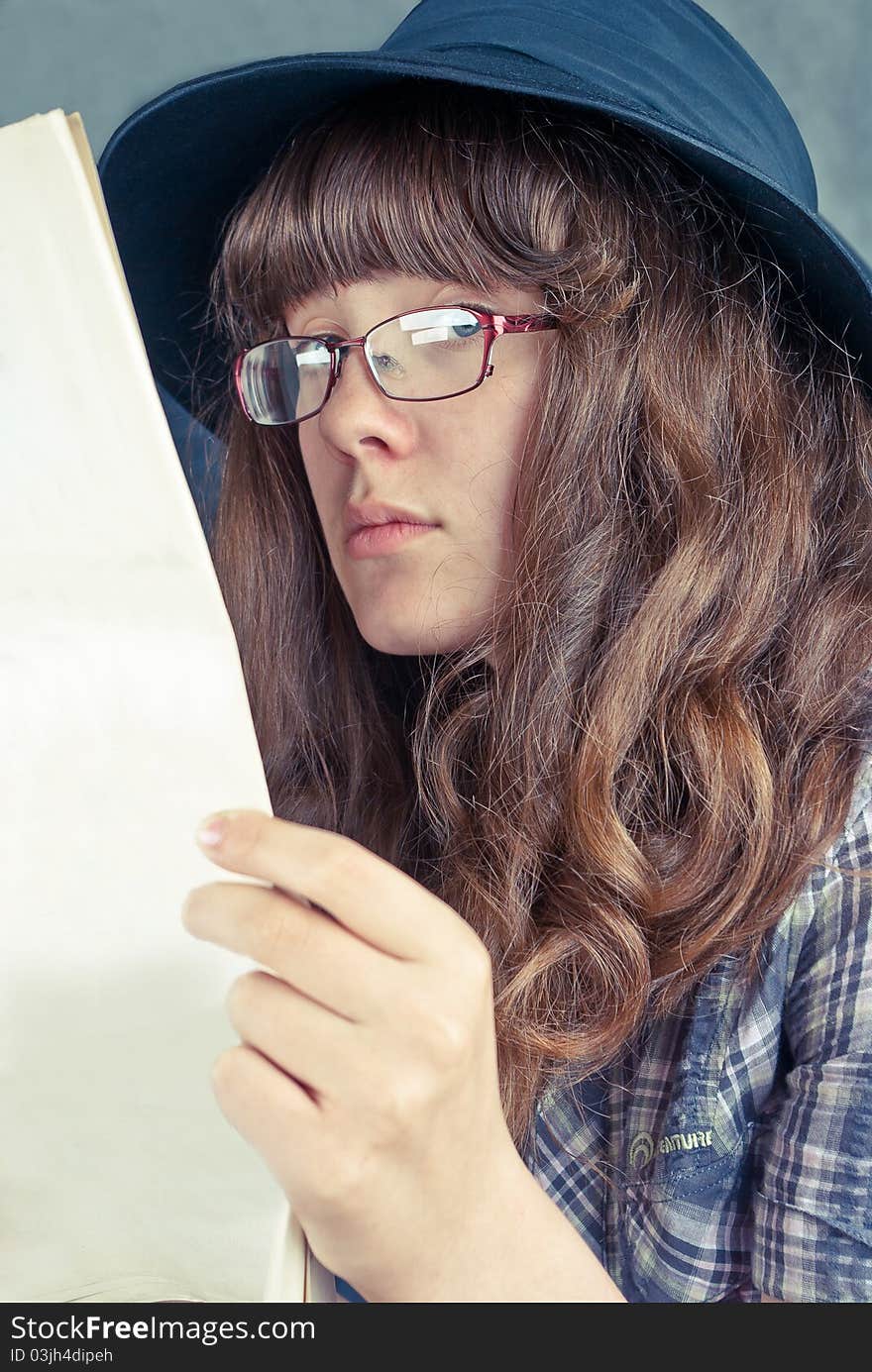 Girl in glasses and black hat reading newspaper. Girl in glasses and black hat reading newspaper