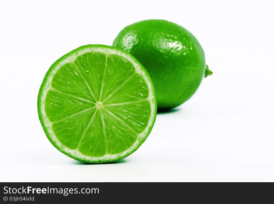 1 / 2 lime in the foreground with a lime behind. 1 / 2 lime in the foreground with a lime behind