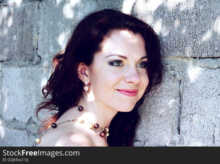 Portrait of beautiful young woman on background a stone wall. Cross processed image