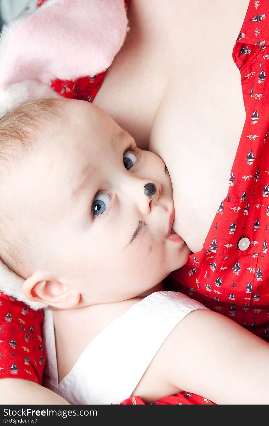 Breast feeding of baby boy with bunny ears . Breast feeding of baby boy with bunny ears .