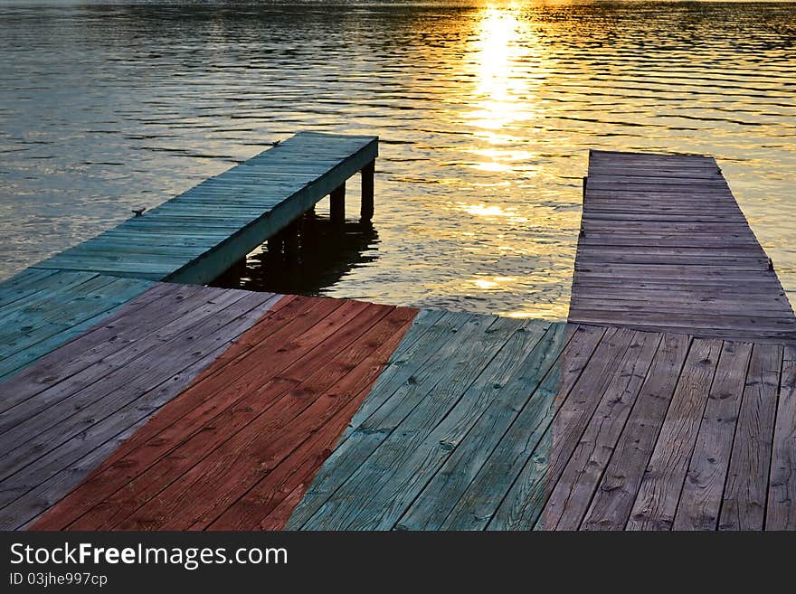 Old wooden boat dock on a lake at sunset. Old wooden boat dock on a lake at sunset