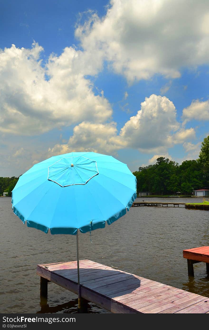 Boat Dock with Umbrella on a lake with clouds