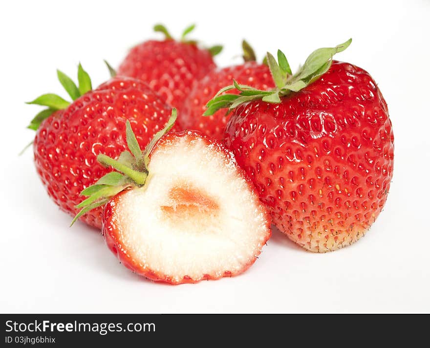 A few ripe strawberries. A one berry is cutted