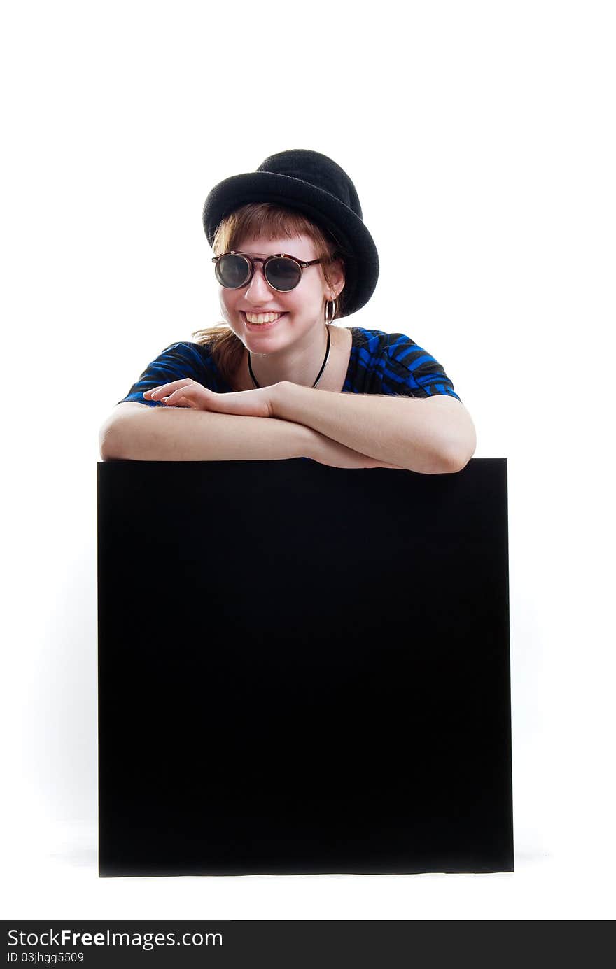 Young woman in black hat and sunglasses on black cube isolated. Young woman in black hat and sunglasses on black cube isolated