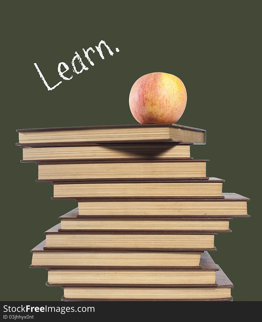 An apple on top of stack of books isolated on green. An apple on top of stack of books isolated on green