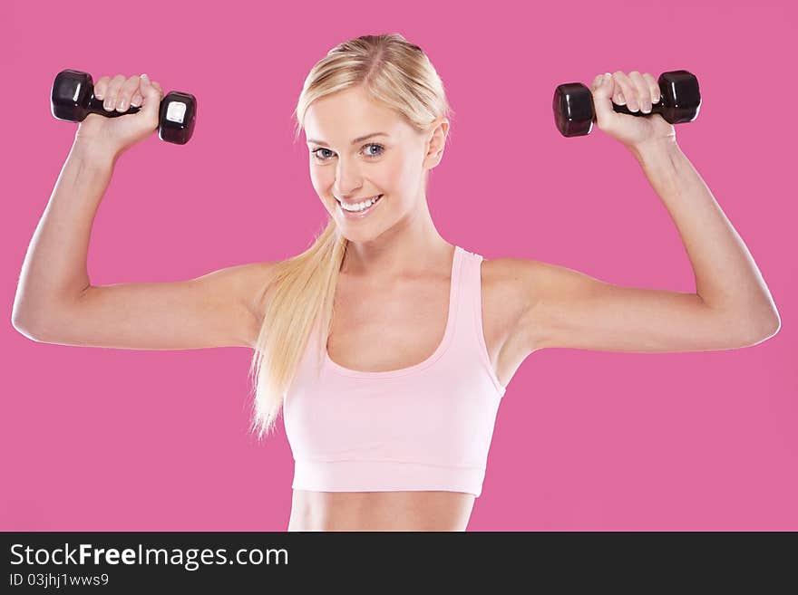 Beautifu happyl blonde fitness model on pink background. Beautifu happyl blonde fitness model on pink background