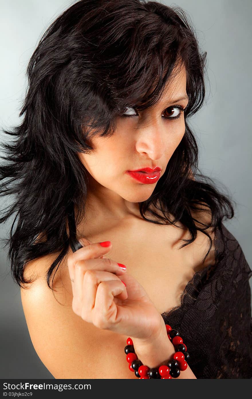 A portrait of a beautiful woman in red lipstick wearing a black lacy top. A portrait of a beautiful woman in red lipstick wearing a black lacy top