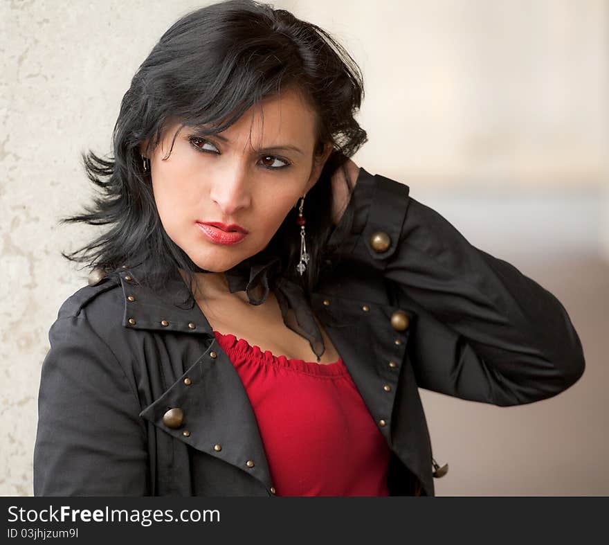 A portrait of a sexy and tough-looking woman in a black jacket and red top. A portrait of a sexy and tough-looking woman in a black jacket and red top