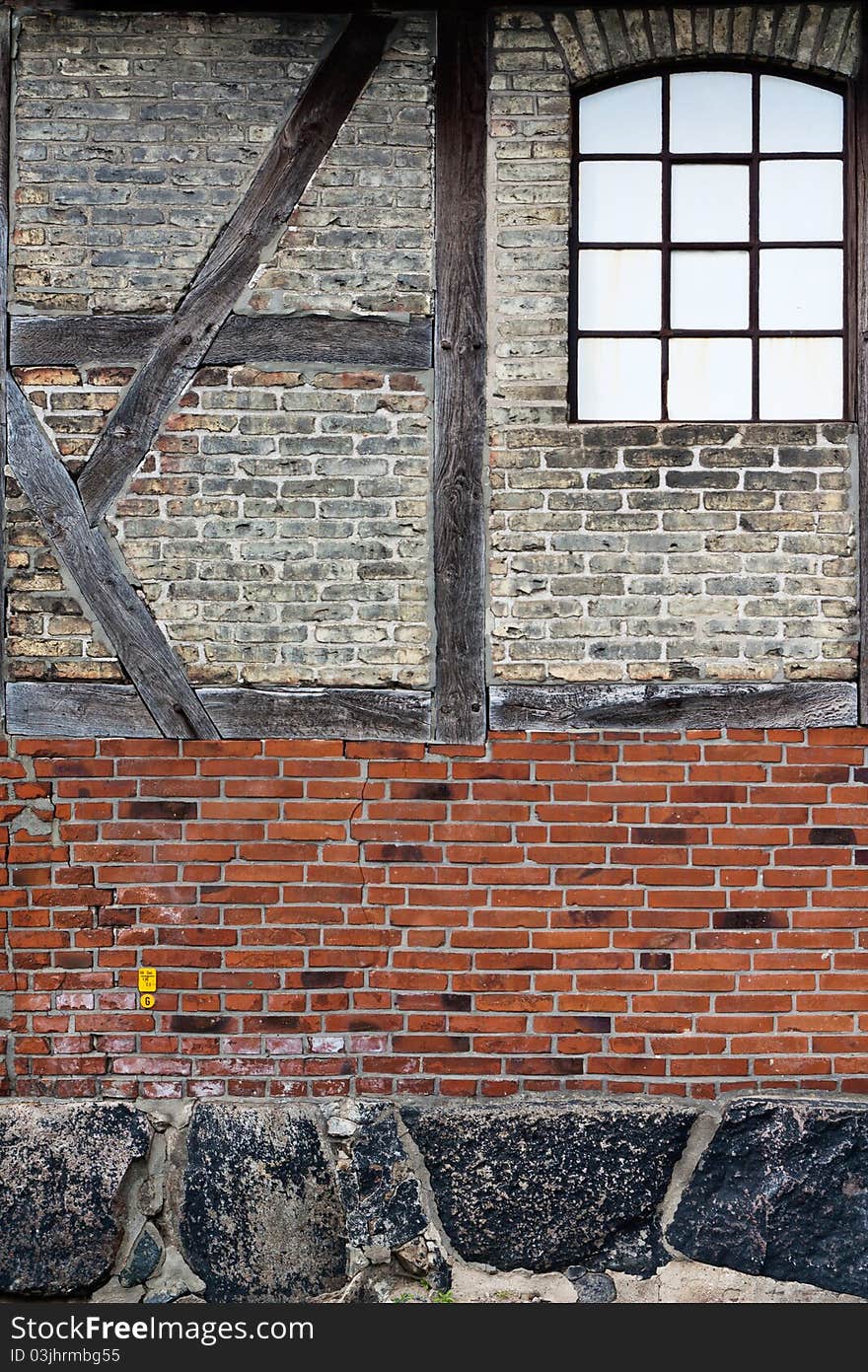 Old brick wall with framework and a window