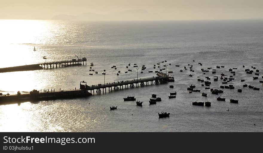 Sunset in Lima, Peru. Fisher boats softly waving in the ocean. Sunset in Lima, Peru. Fisher boats softly waving in the ocean