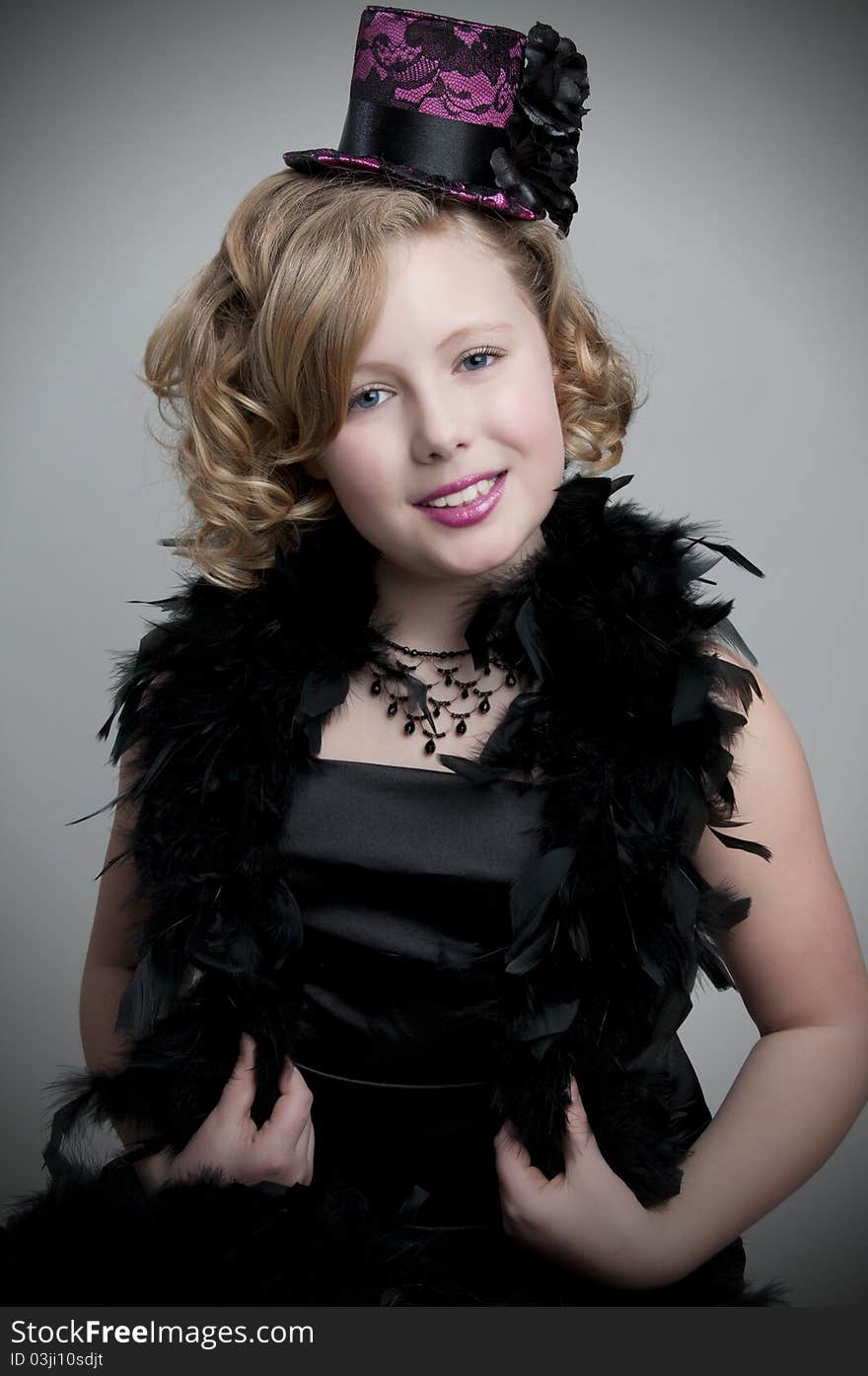 Adorable child model wearing feather boa and fancy hat. Adorable child model wearing feather boa and fancy hat