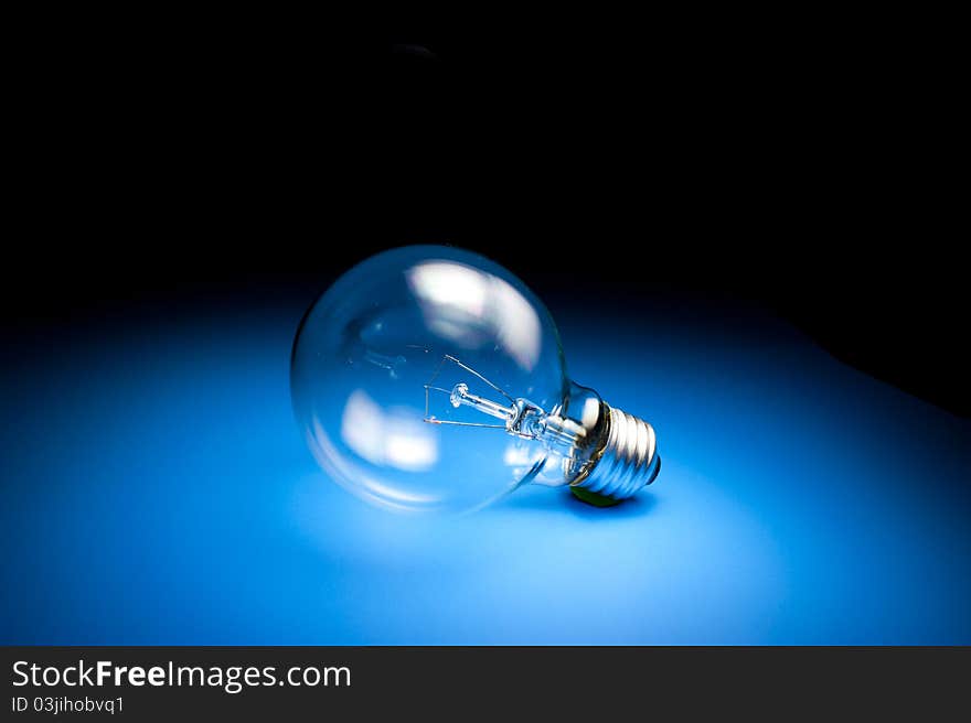 Light Bulb on place blue floor with light from above. Light Bulb on place blue floor with light from above
