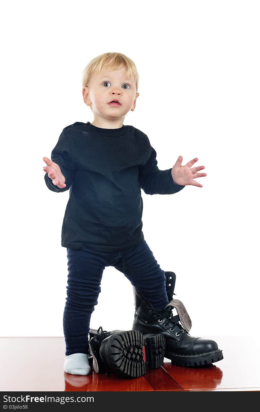 Two years old boy in big shoes on white. Two years old boy in big shoes on white