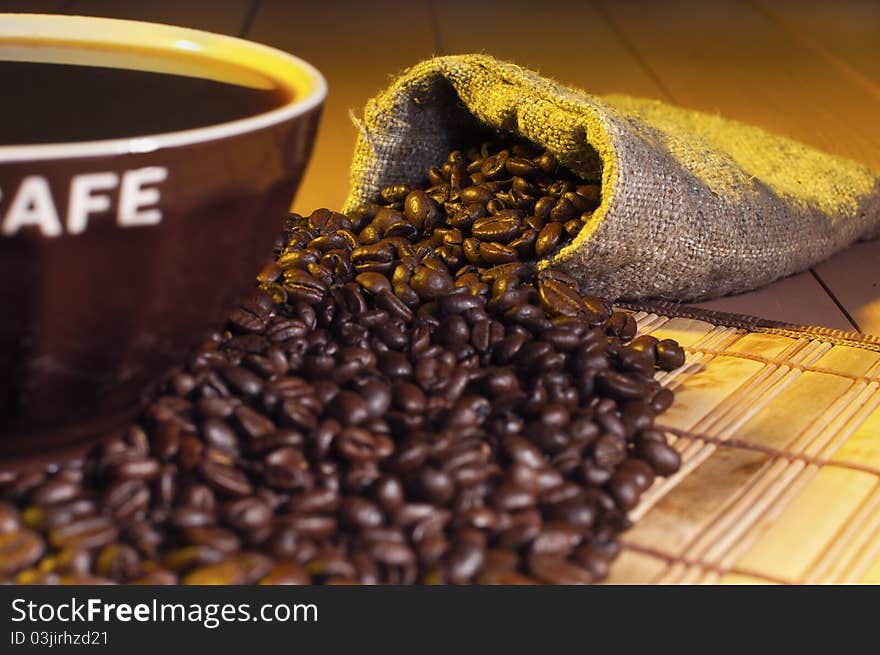 Coffee beans and cup of coffee on the table. Coffee beans and cup of coffee on the table