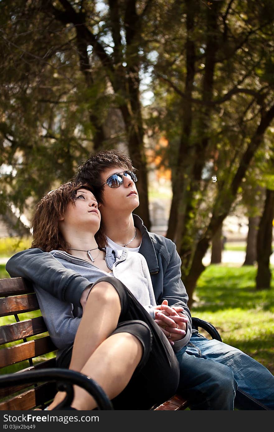 Attractive couple sitting on bench in the park