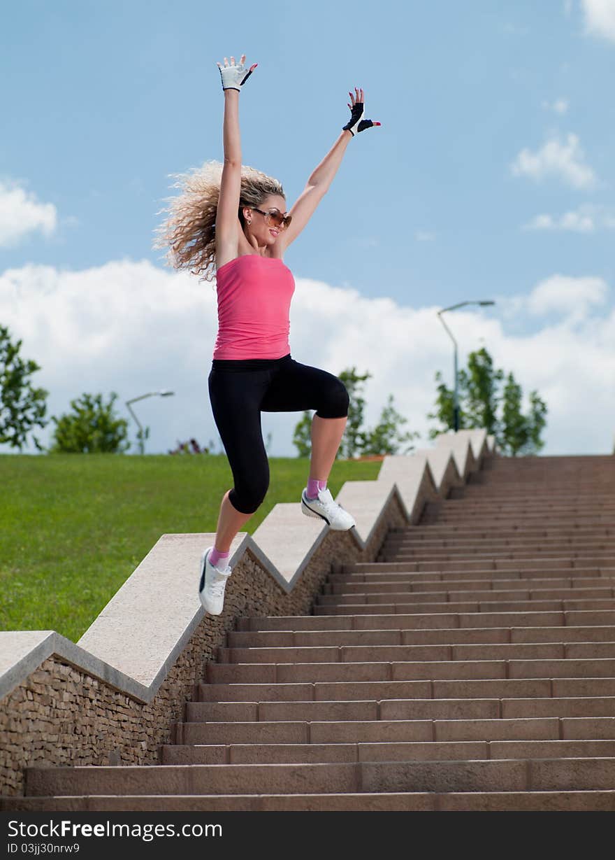 Woman in sportswear jumping over the stairs