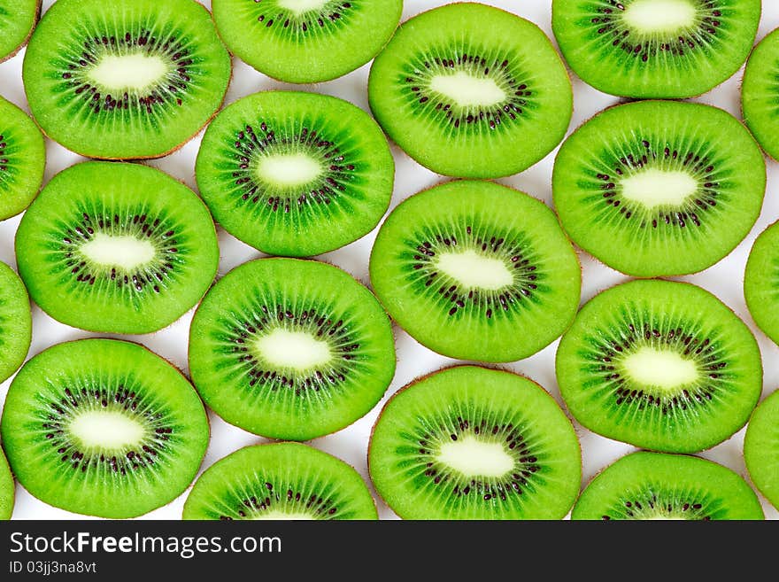 Kiwi, cut into slices laid on a white background