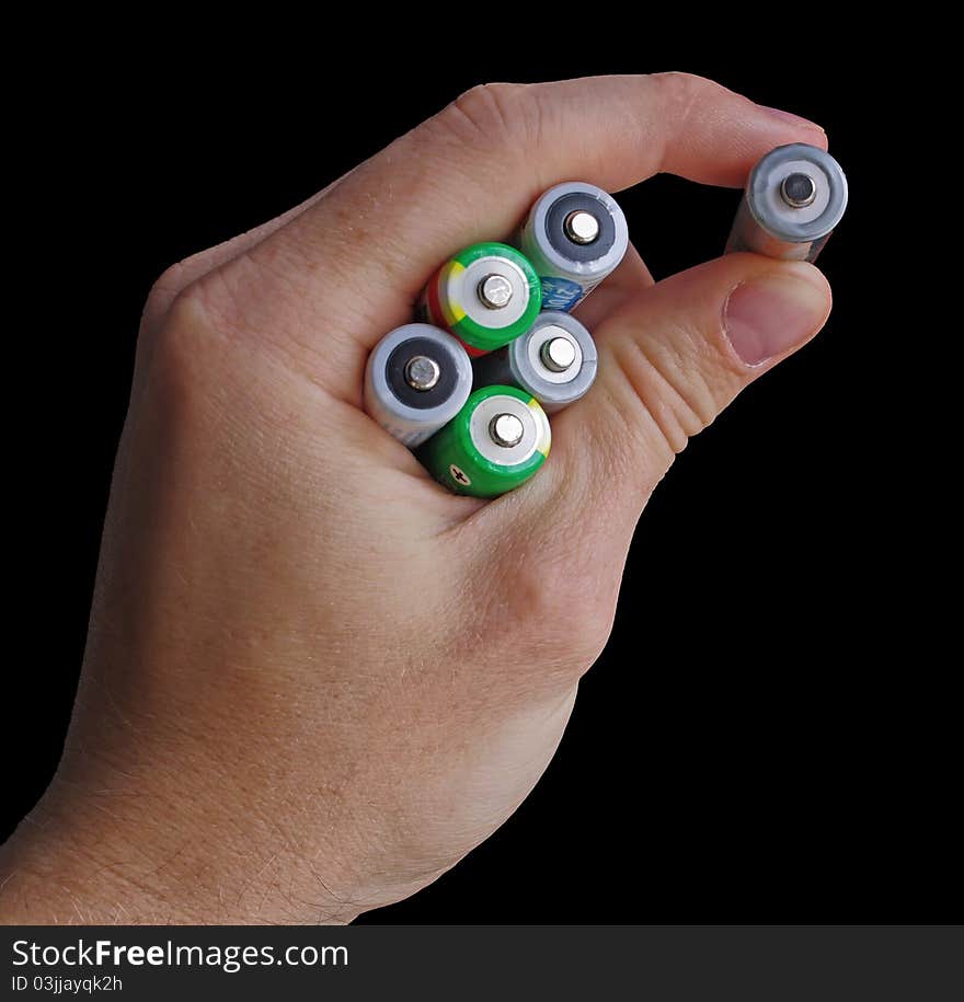 Hand holding an AA batteries isolated on black