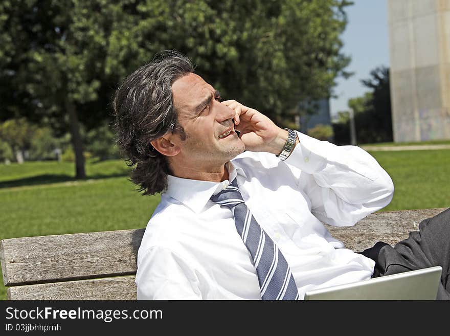 Successful businessman talking on the phone outdoors, expo Portugal