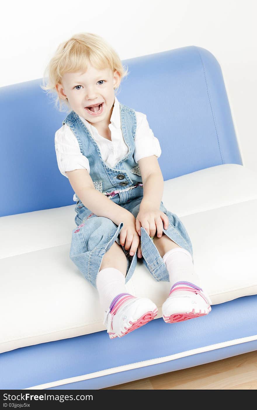 Little girl sitting on sofa. Little girl sitting on sofa