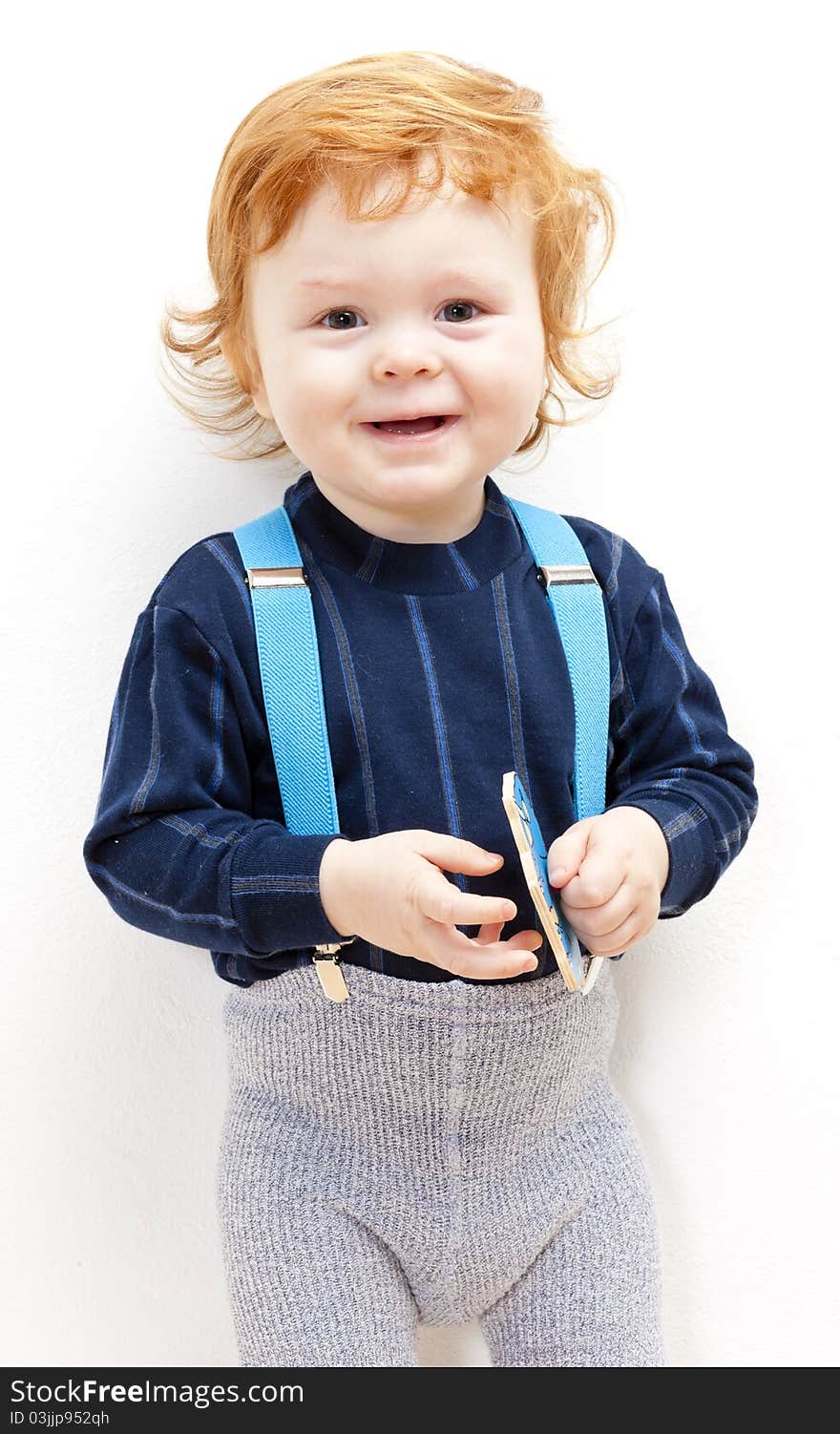 Portrait of standing little boy with a toy