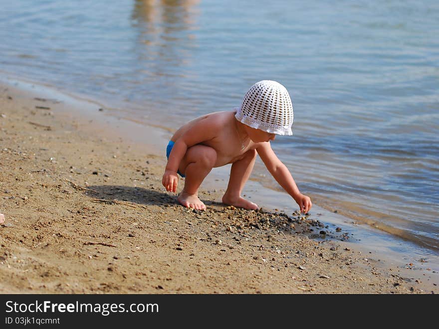 Little girl is gather stones on the beach. Little girl is gather stones on the beach