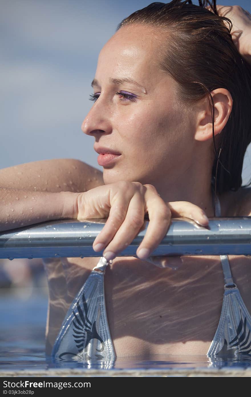 Woman in swimming pool resting on the bar