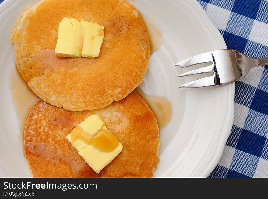 Freshly baked homemade pancakes topped with butter and syrup. Freshly baked homemade pancakes topped with butter and syrup.