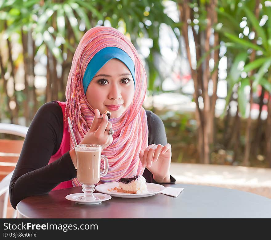 Young muslim woman relaxed while eating a cakes. Young muslim woman relaxed while eating a cakes