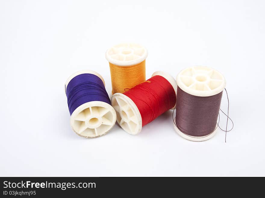 Four different colors of spools thread.