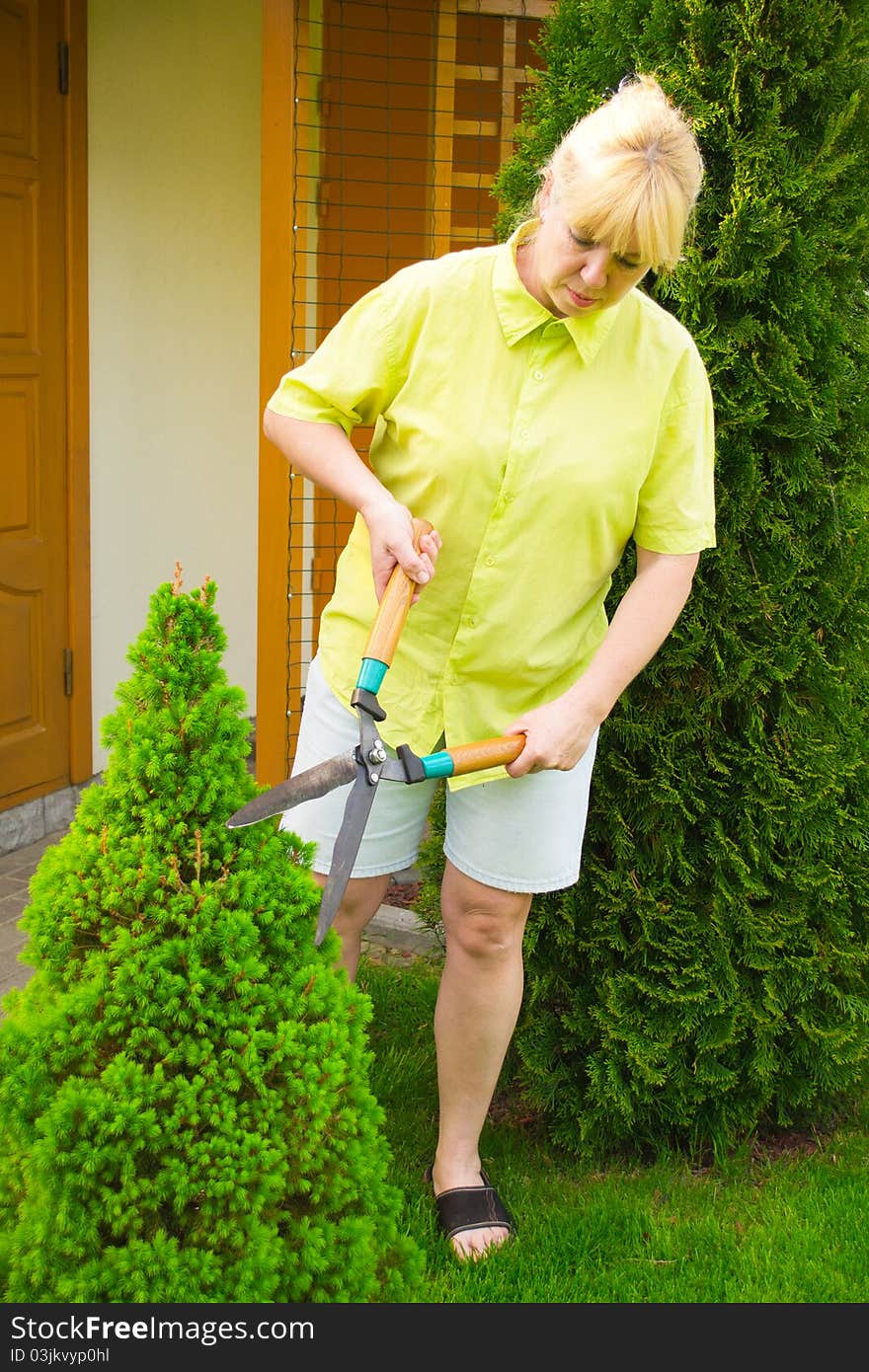 Woman cut bush clippers .