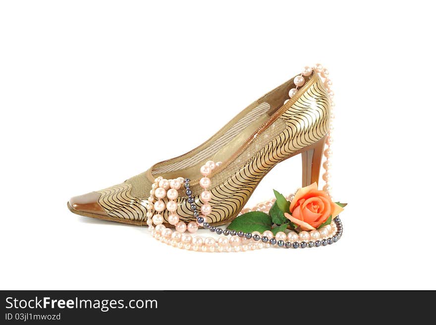 Woman golden shoe with pearl necklace   on a white background