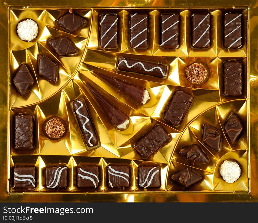 Chocolate sweets, inside a golden open box