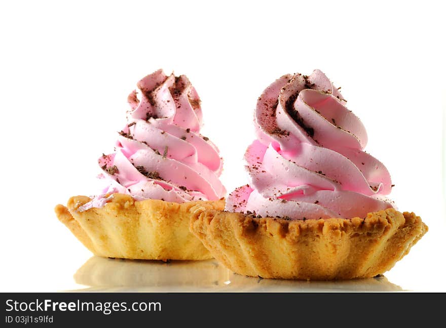 Two cupcakes with pink cream, isolated on a white background. Two cupcakes with pink cream, isolated on a white background