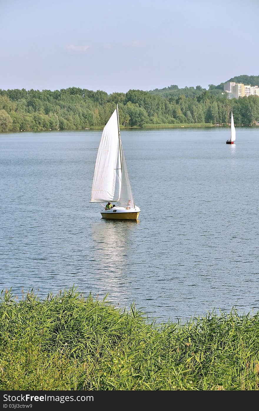 Photo shows a sailboat on the lake inland. Photo shows a sailboat on the lake inland.