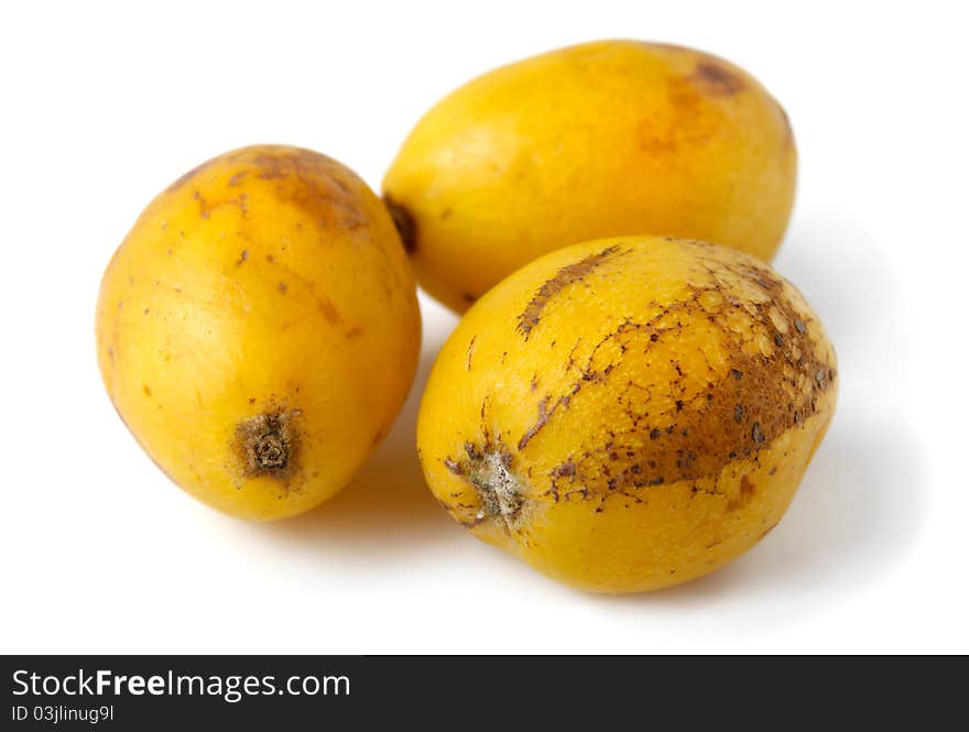 Three yellow loquat fruits - Eriobotrya japonica - Isolated on white background