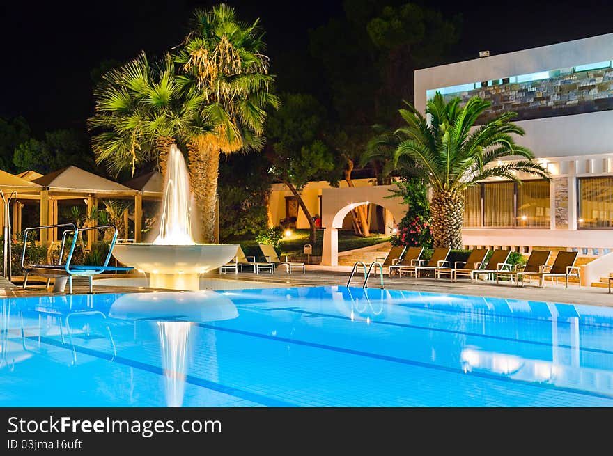 Water pool and fountain at night - vacation background