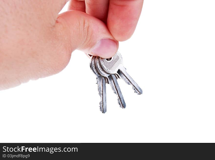 Three silver keys in a hand isolated on white background