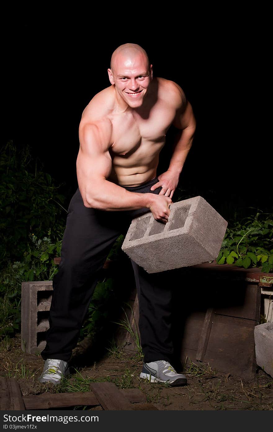 Athletic young man in the slums at night