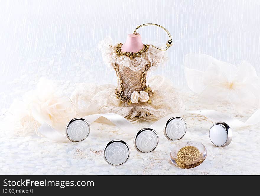 Wedding still life with buttons, satin ribbon, statue in dress