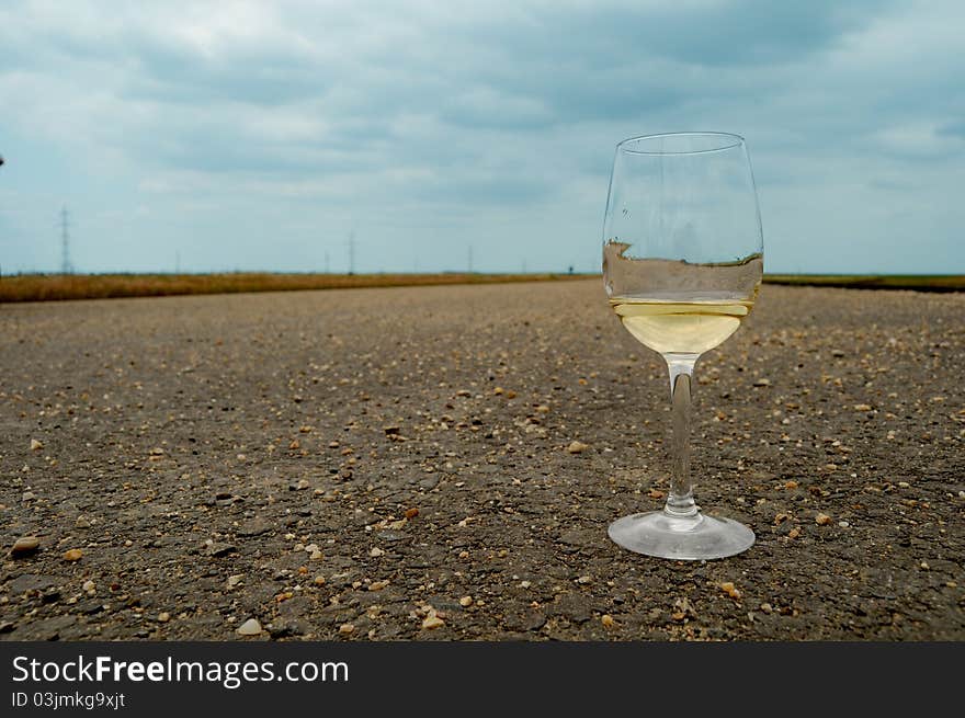 Glass of wine on the road. Concept image for drinking and driving. Glass of wine on the road. Concept image for drinking and driving