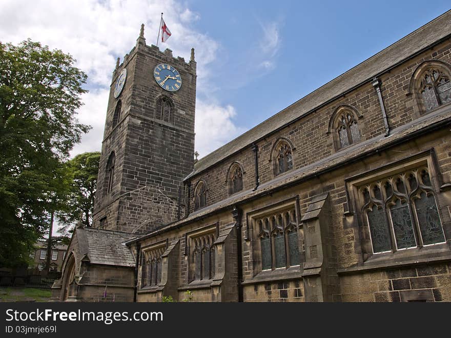 The Parish Church of St Michael and All Angels in Haworth Yorkshire under a blue summer sky. The Parish Church of St Michael and All Angels in Haworth Yorkshire under a blue summer sky