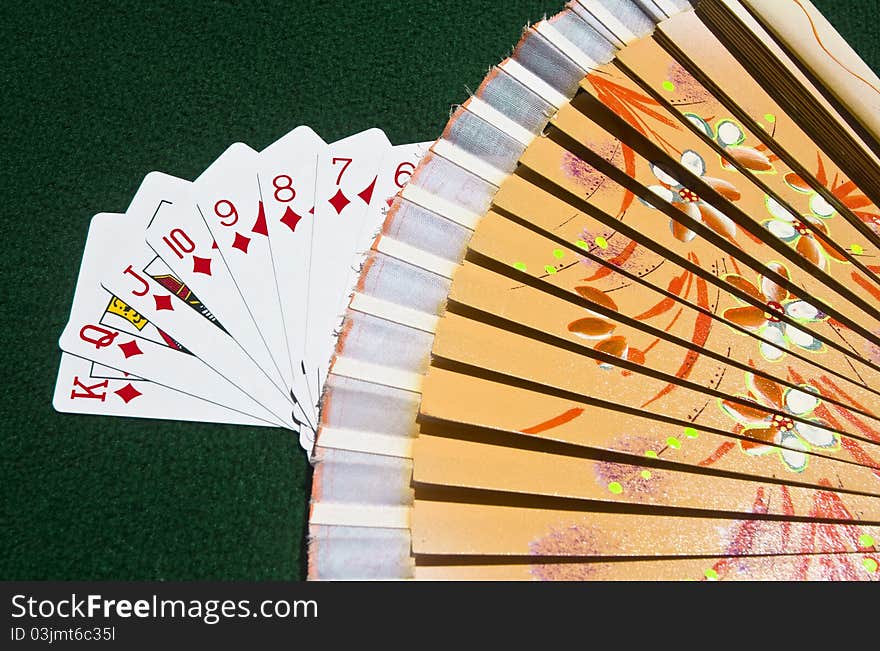 The Diamonds of the Poker playing cards put streetwise covered by a traditional Spanish wooden fan. The Diamonds of the Poker playing cards put streetwise covered by a traditional Spanish wooden fan.