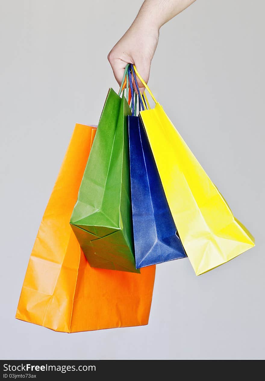 Human hand with some shopping bags with different colors