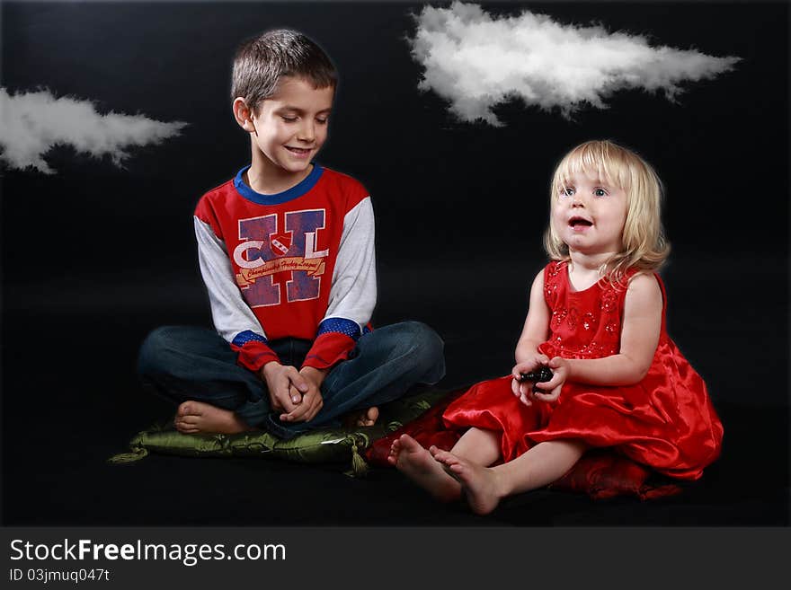 Studio shot of two children playing a fantasy game : 'Close your eyes, sister, and imagine we are in a fairy tale'. Studio shot of two children playing a fantasy game : 'Close your eyes, sister, and imagine we are in a fairy tale'...