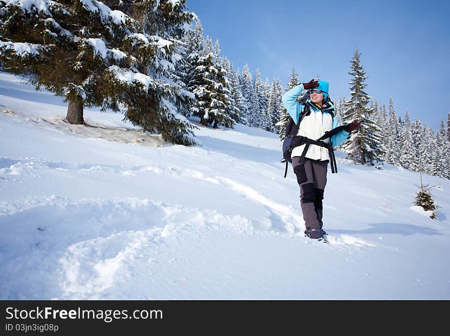 Hiker is looking for the way on the map in snow forest. Hiker is looking for the way on the map in snow forest