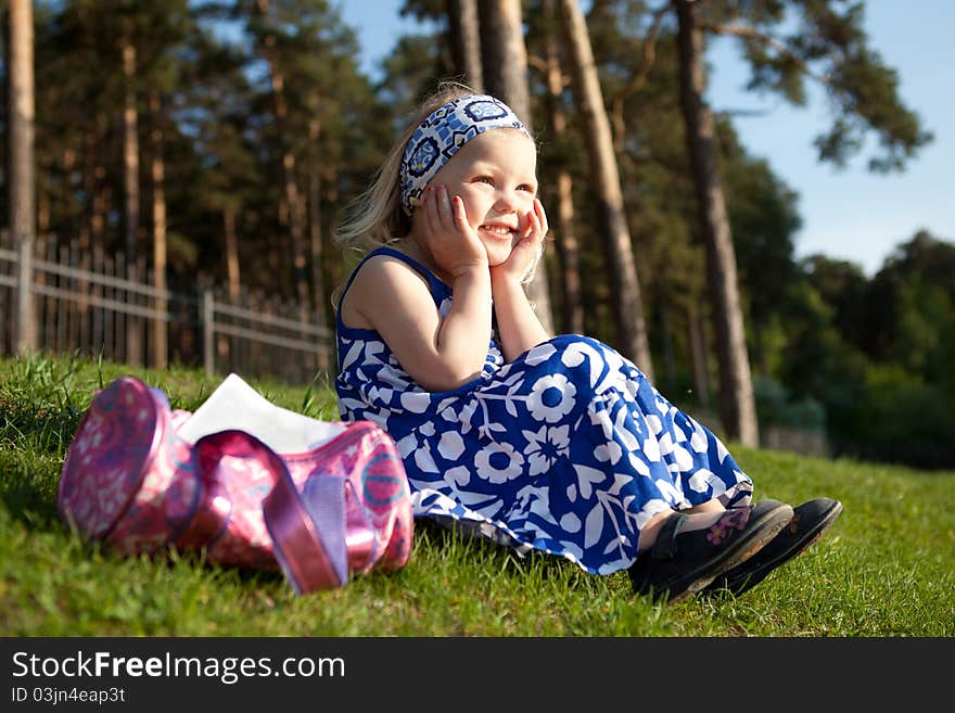 Merry Beautiful Girl Sitting On Green Grass