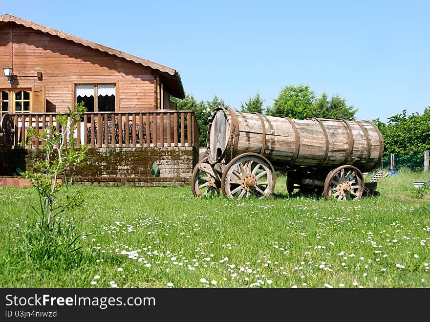 Wooden house with an old tank barrel