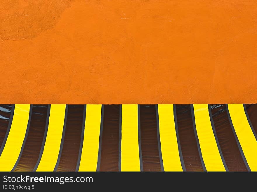 A colorful plastic tent at orange wall