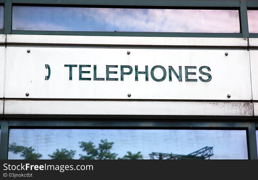 A sign indicating public telephones